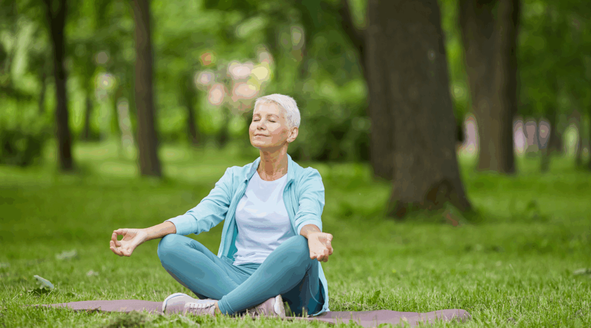 woman sitting on the grass meditating