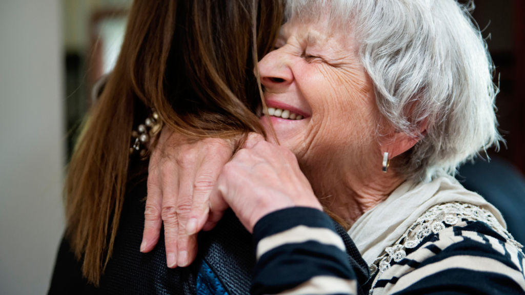 old woman hugging a younger woman