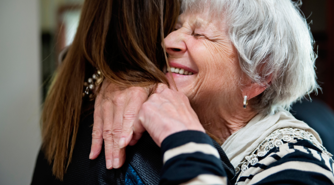 old woman hugging a younger woman